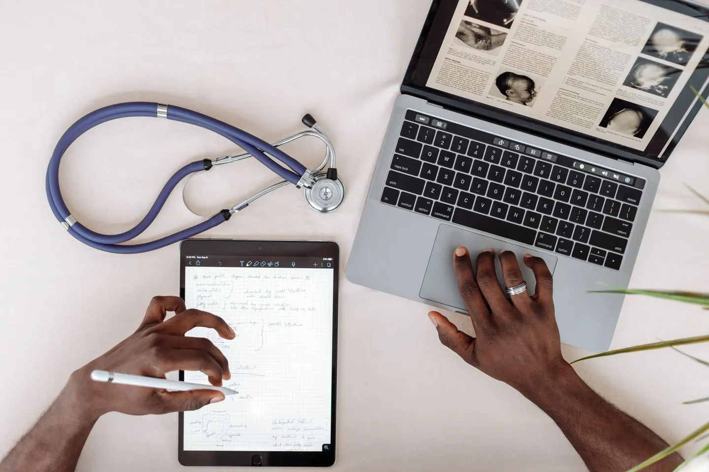 Healthcare SEO in 2026: overhead view of a desk with a stethoscope, tablet, and laptop, representing the work of ranking a medical practice across the Local Map Pack, organic results, and Google AI Overview with MedicalBusiness and Physician schema, healthcare-directory citations, and condition pages